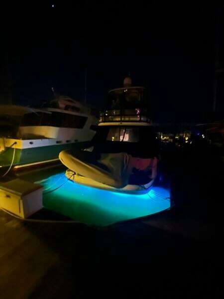 2005 Sea Ray 500 Sedan Bridge yacht with blue underwater lights at night.
