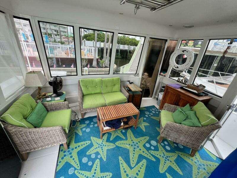Interior of 2000 Carver 506 Motor Yacht with green seating and starfish-patterned rug.