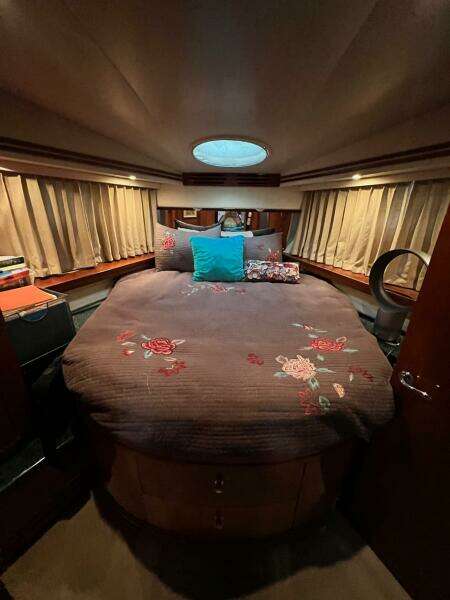 Luxurious bedroom in 2000 Carver 506 Motor Yacht with floral bedding and ambient lighting.