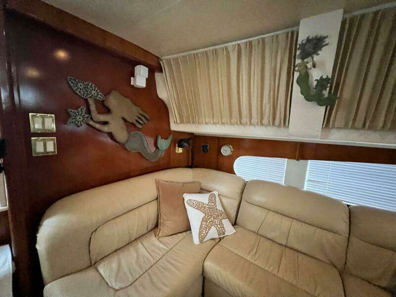 Interior of 2000 Carver 506 Motor Yacht with mermaid decor and beige seating.
