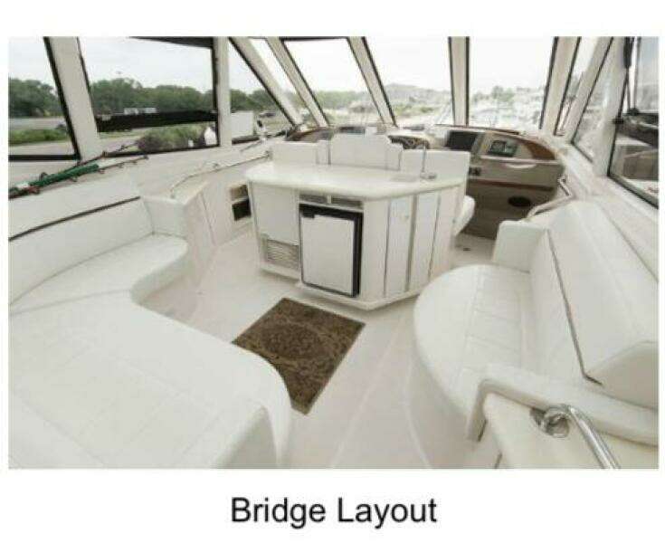 Bridge layout of 2000 Carver 506 Motor Yacht with white seating and helm.