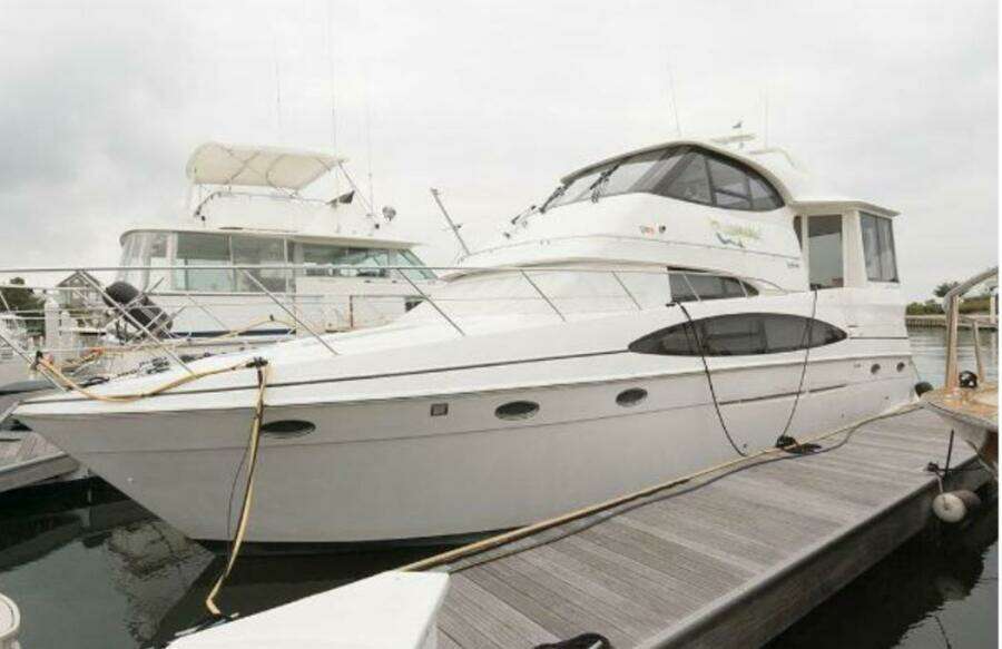 2000 Carver 506 Motor Yacht docked at marina, showcasing sleek design and spacious deck.