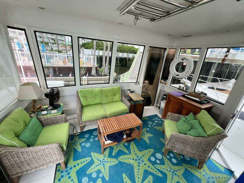 Interior of 2000 Carver 506 Motor Yacht with green seating and starfish-patterned rug.