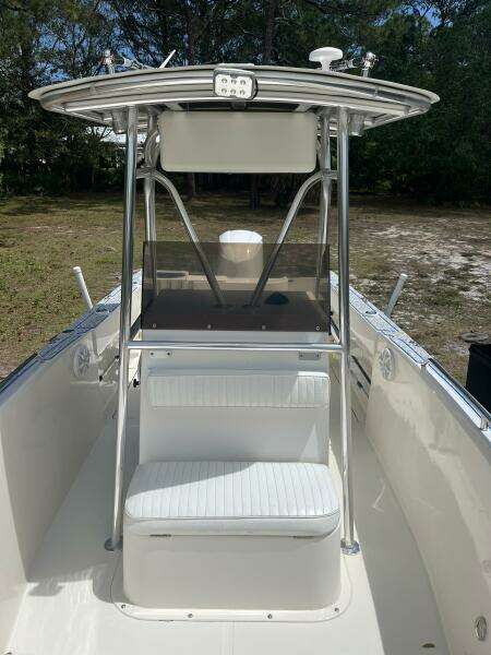 1998 Blue Fin 25 Center Console boat with T-top and seating, parked outdoors.