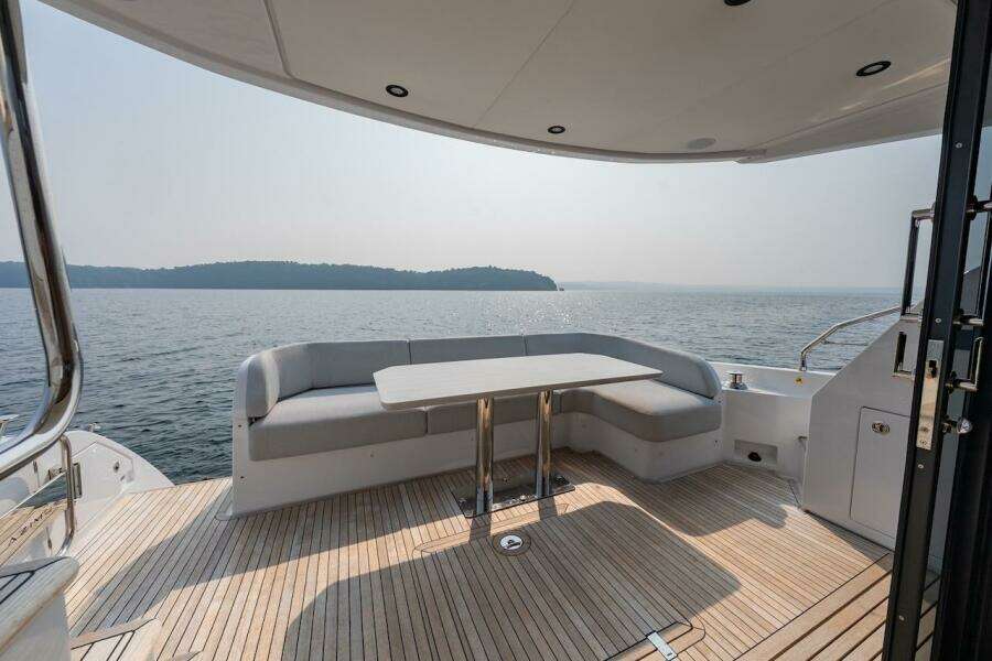 Luxury Azimut Fly 53 yacht deck with seating, overlooking serene water and distant shoreline.