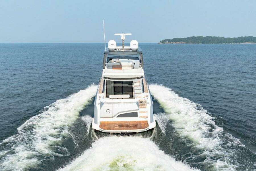 2023 Azimut Fly 53 yacht cruising on open water, rear view.