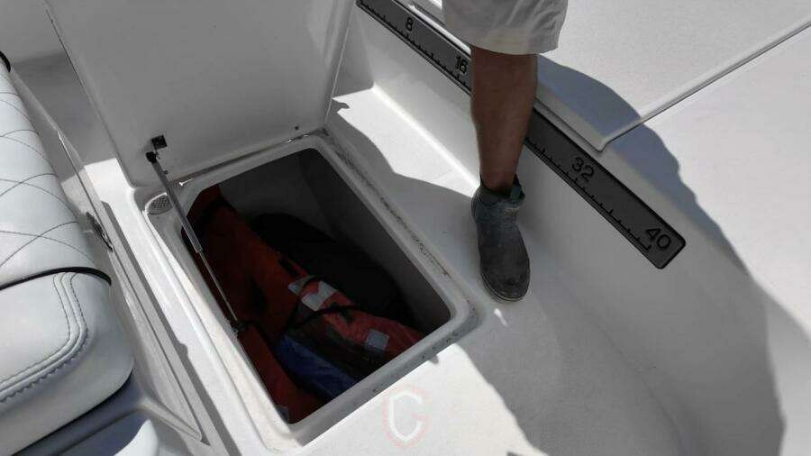 Open storage compartment on 2023 CG Boat Works 35 M-Series, featuring a measuring scale.