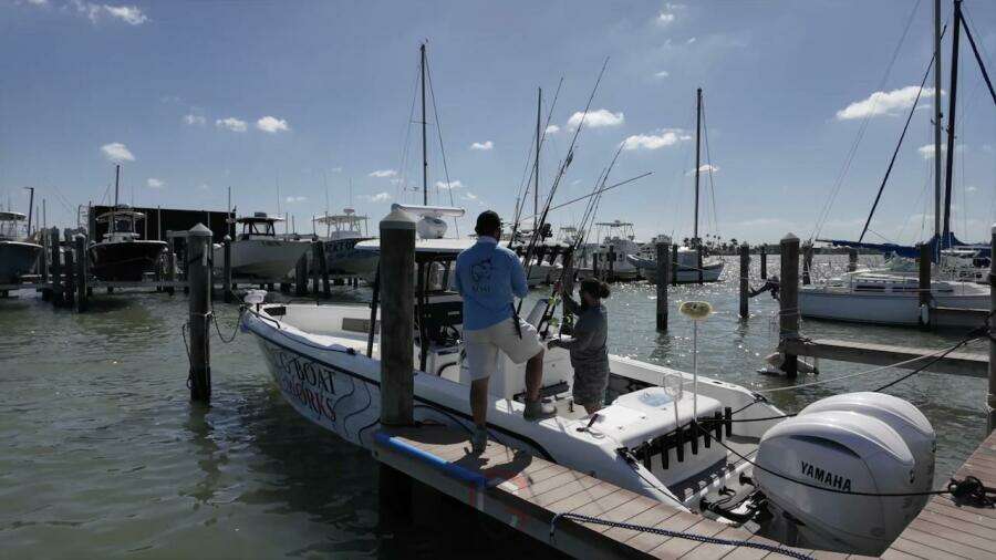 2023 CG Boat Works 35 M-Series docked with people preparing fishing gear.