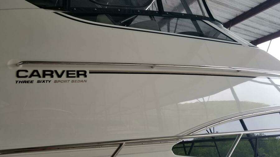 2004 Carver 360 Sport Sedan boat side view with logo under a canopy.