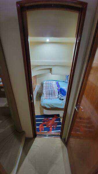 Interior cabin of a 2004 Carver 360 Sport Sedan with cozy bedding and nautical decor.