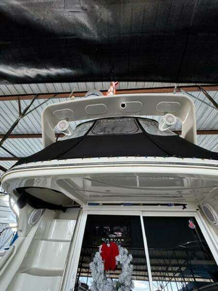 2004 Carver 360 Sport Sedan yacht under a covered dock, rear view.