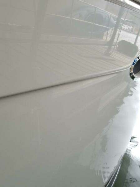 Close-up of a 2004 Carver 360 Sport Sedan boat hull reflecting water.
