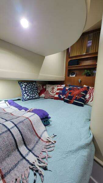 Cozy cabin interior of a 2004 Carver 360 Sport Sedan with decorative pillows and blankets.
