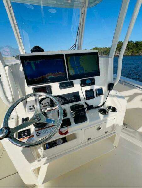 2021 Cobia 301 Center Console boat dashboard with navigation screens and steering wheel.