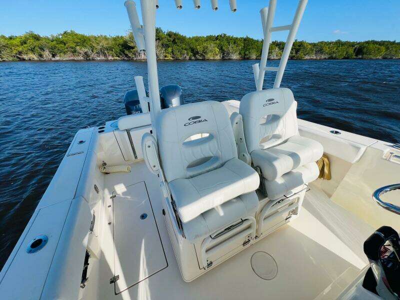 2021 Cobia 301 Center Console boat with dual white seats on calm water.