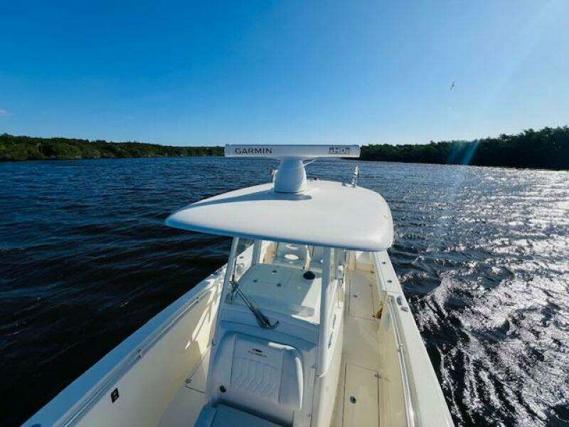 2021 Cobia 301 Center Console boat on a sunny day, cruising on open water.