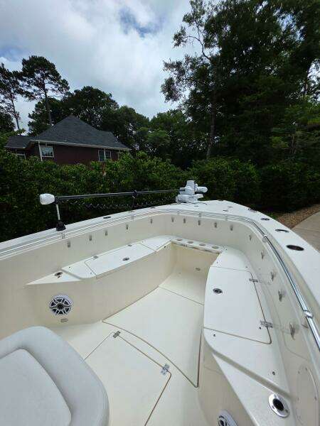 2021 Cobia 301 Center Console boat with spacious seating, surrounded by lush greenery.