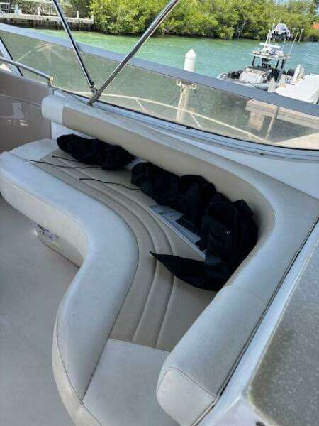 2006 Carver 43 Motor Yacht with white curved seating and scenic waterfront view.