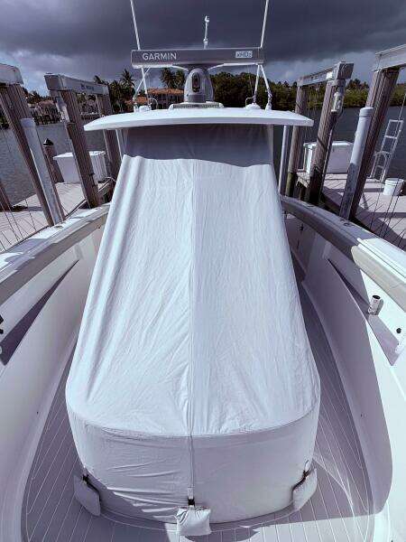 2024 Scout 400 LXF boat with covered console, docked under cloudy skies.