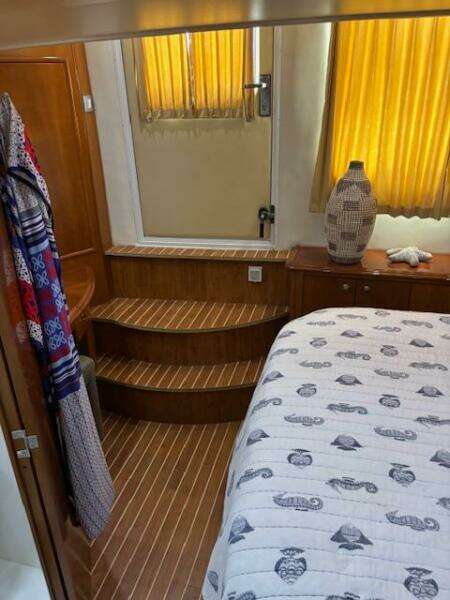 Interior of 2006 Carver 43 Motor Yacht with wooden steps and nautical-themed bedding.