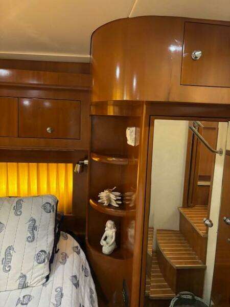 Luxurious 2006 Carver 43 Motor Yacht interior with wooden cabinetry and cozy bedroom.