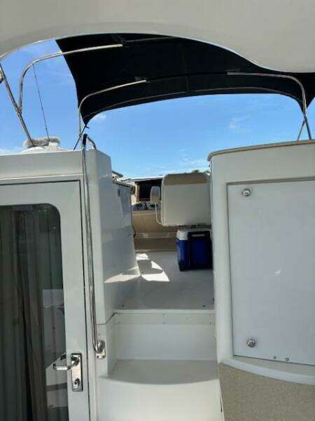 2006 Carver 43 Motor Yacht with open deck and canopy under clear blue sky.