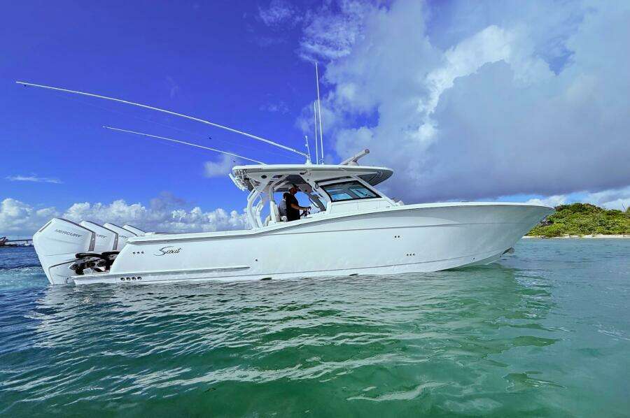 2024 Scout 400 LXF boat on clear water under a blue sky.