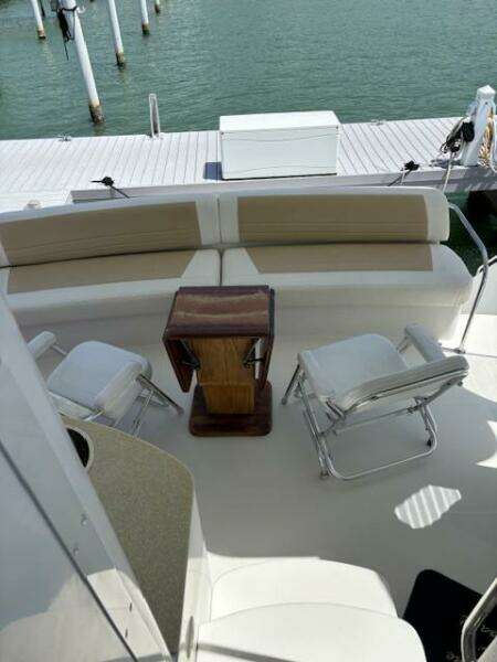2006 Carver 43 Motor Yacht deck with seating and table, docked by the water.