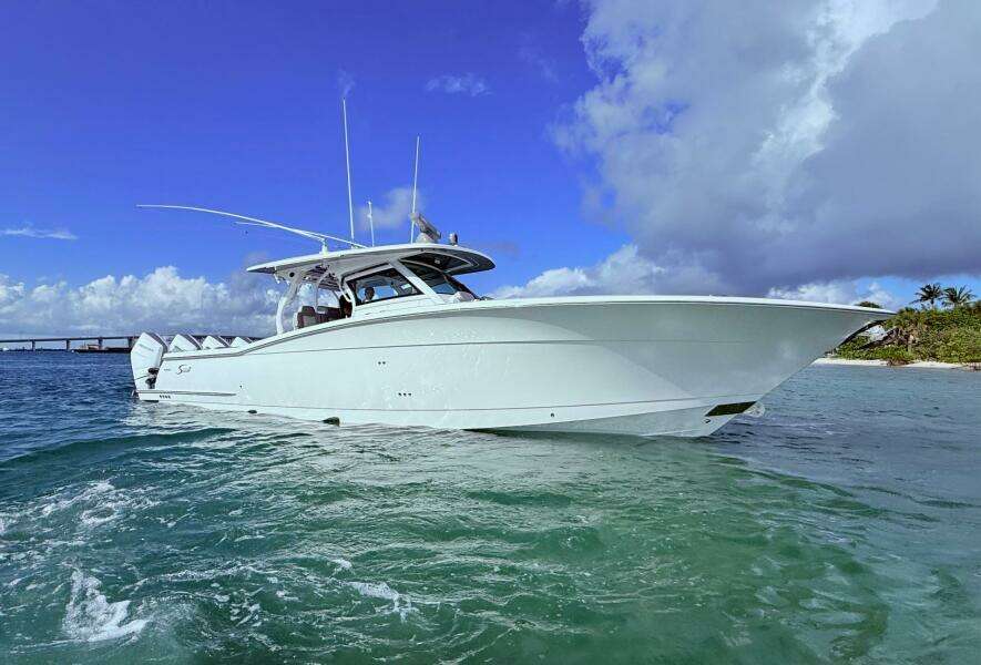 2024 Scout 400 LXF boat on clear blue water under a bright sky.