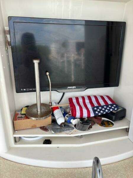 2006 Carver 43 Motor Yacht interior with TV, American flag, and assorted items on shelf.