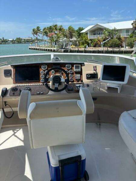 Helm of 2006 Carver 43 Motor Yacht with navigational equipment, overlooking a scenic waterfront.