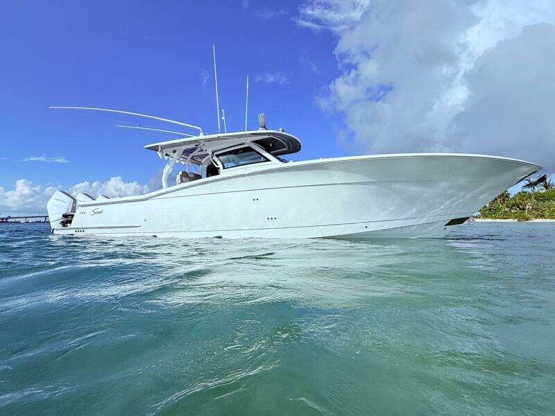 2024 Scout 400 LXF boat on clear blue water under a bright sky.