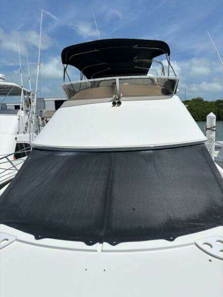 2006 Carver 43 Motor Yacht with black sunshade, docked under blue sky.