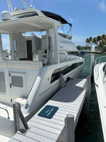 2006 Carver 43 Motor Yacht docked at marina, sunny day, clear skies, palm trees in background.
