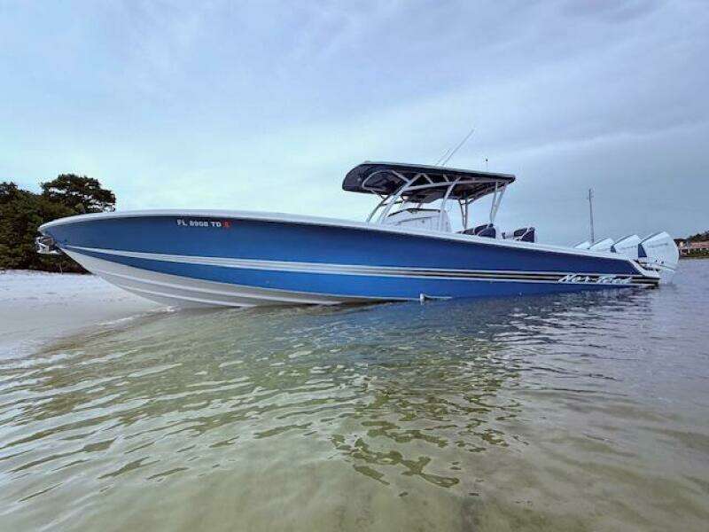 2022 Nor-Tech 390 Sport Center Console boat in shallow water, showcasing sleek blue design.