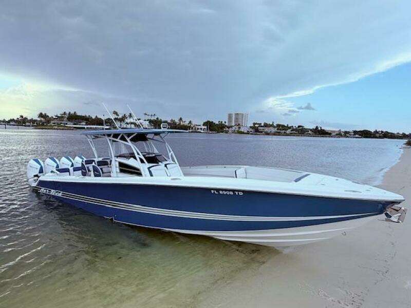 2022 Nor-Tech 390 Sport Center Console boat on sandy beach, calm water background.