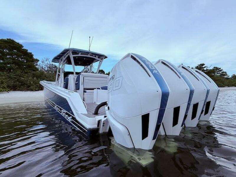 2022 Nor-Tech 390 Sport Center Console boat with multiple outboard engines in shallow water.