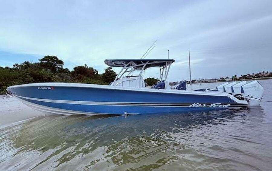 2022 Nor-Tech 390 Sport Center Console boat in shallow water, featuring a sleek blue design.