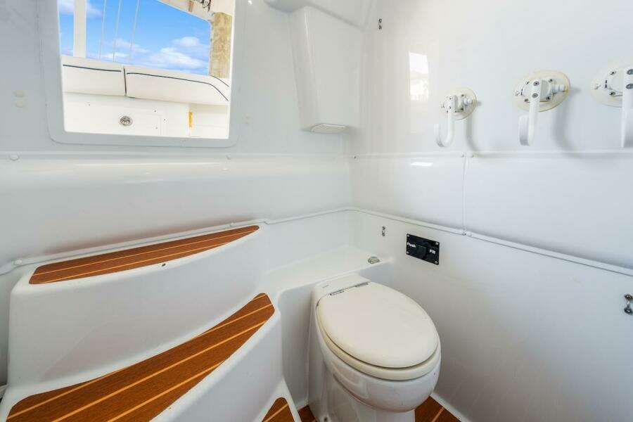 Interior of 2015 Yellowfin 39 boat featuring a compact marine toilet and wooden steps.