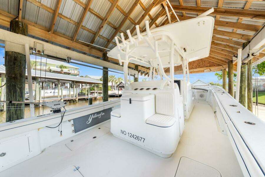 2015 Yellowfin 39 boat docked under a wooden shelter.