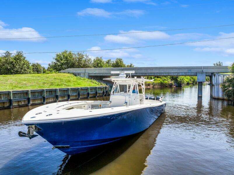 2015 Yellowfin 39 boat cruising on a calm river under a blue sky.