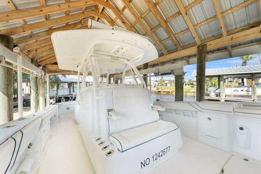 2015 Yellowfin 39 boat docked under wooden shelter, featuring spacious seating and sleek design.