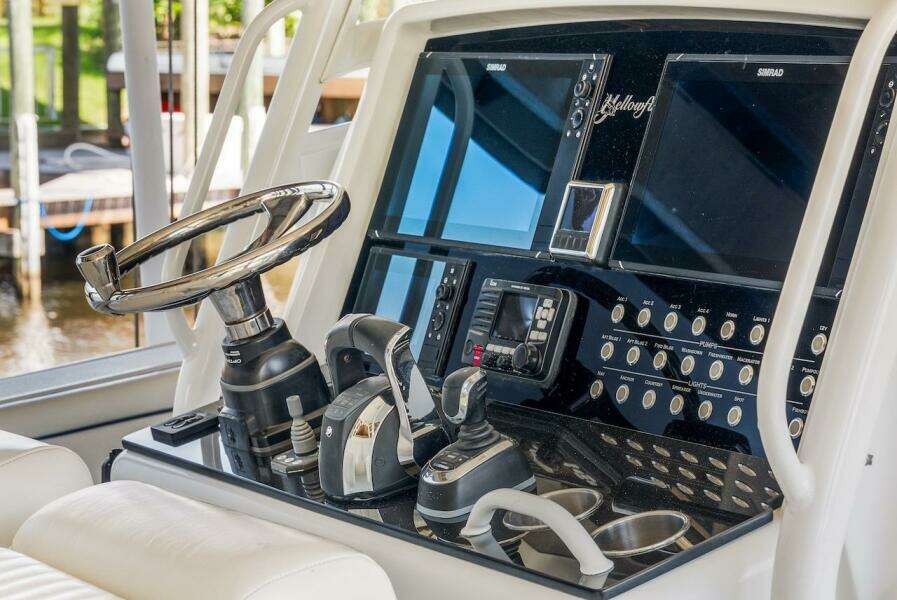 Control panel of a 2015 Yellowfin 39 boat with steering wheel and navigation screens.