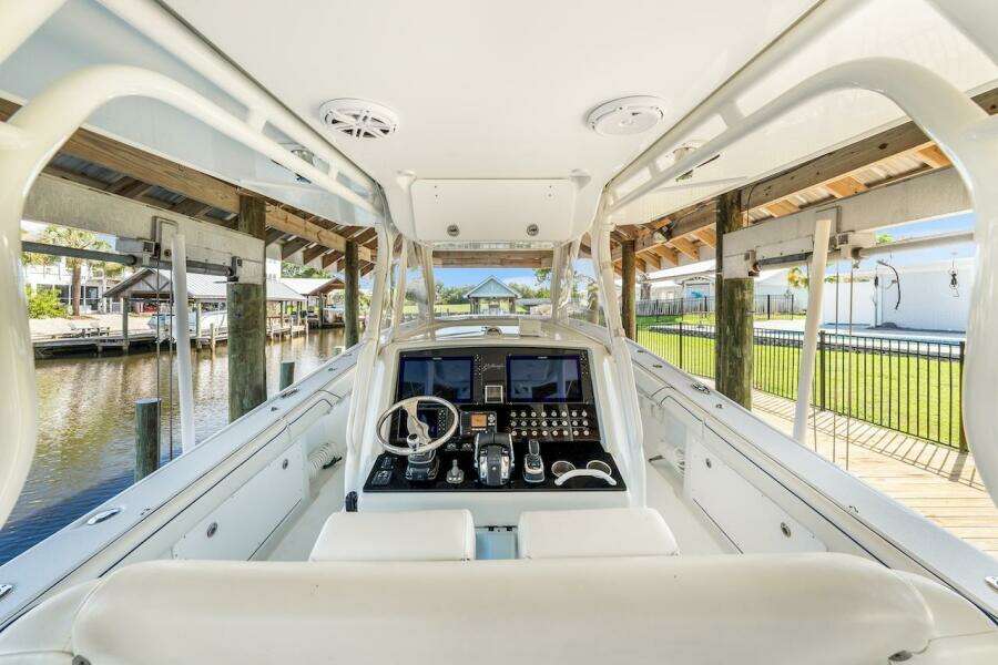2015 Yellowfin 39 boat cockpit with advanced navigation system, docked in a serene marina setting.