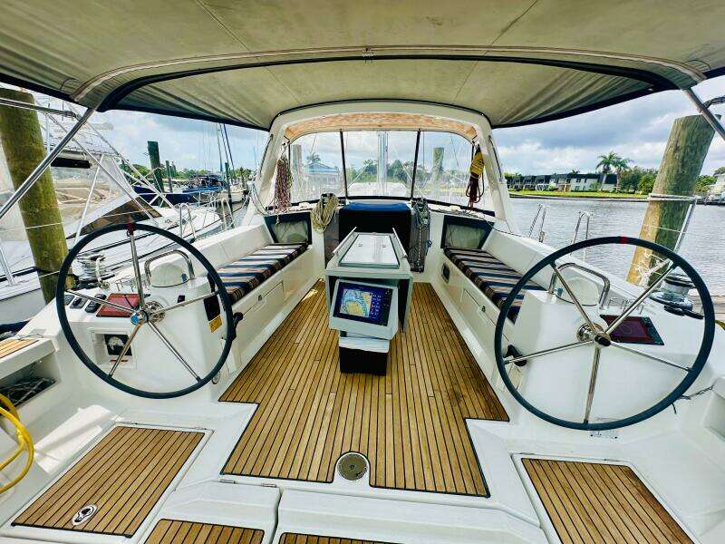 Cockpit of 2015 Beneteau Oceanis 45 sailboat with dual steering wheels and teak flooring.