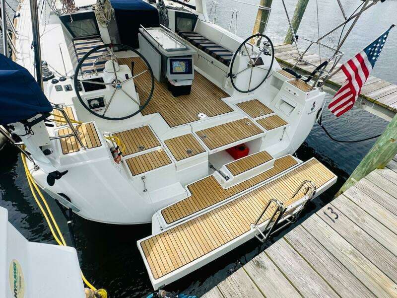2015 Beneteau Oceanis 45 sailboat with dual steering wheels, docked with American flag.