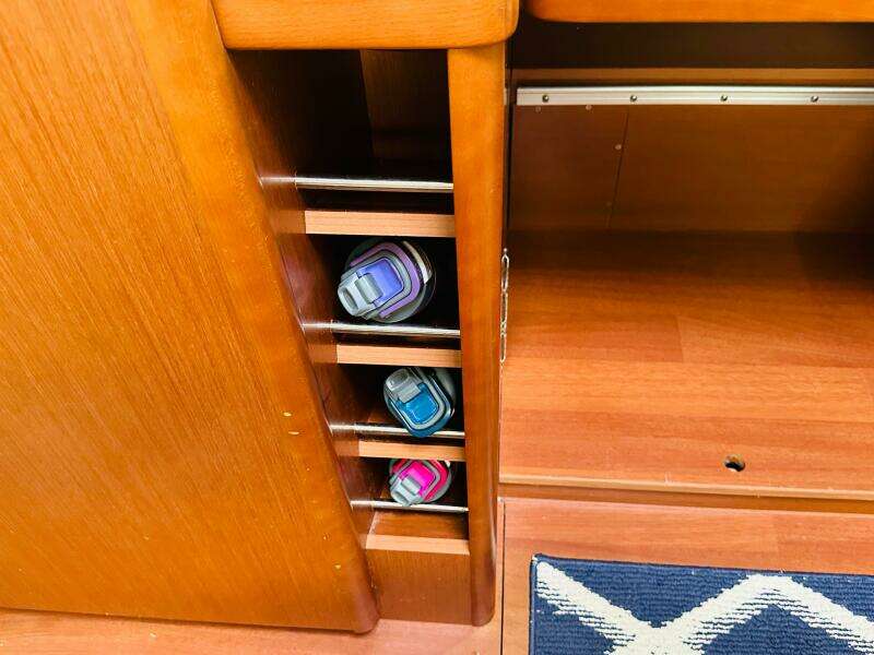 Wooden interior storage with water bottles on a 2015 Beneteau Oceanis 45 yacht.