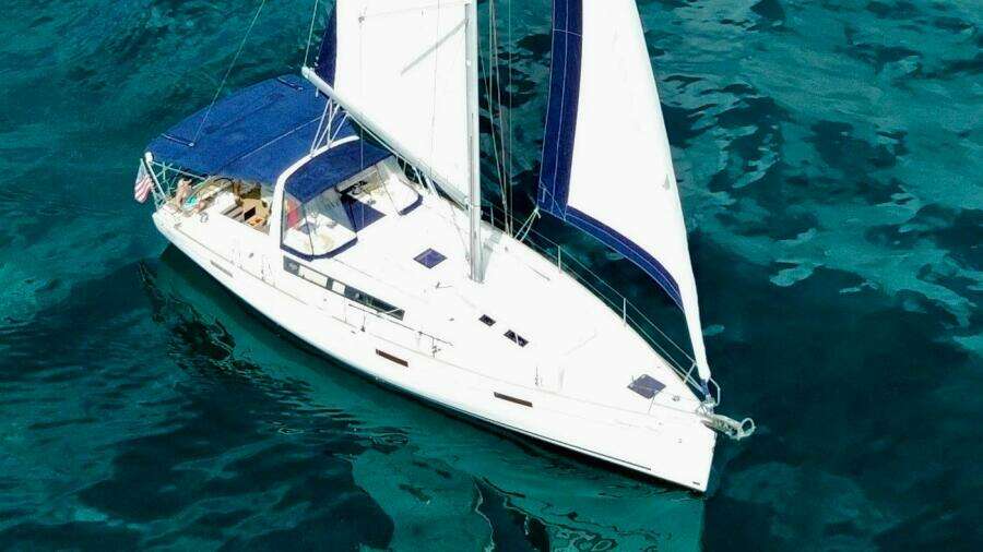 2015 Beneteau Oceanis 45 sailing on clear blue water.
