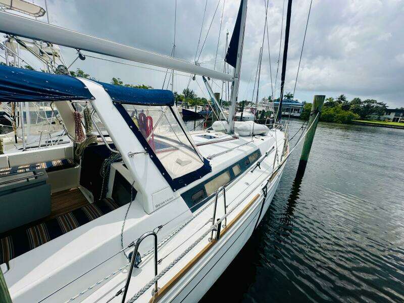 2015 Beneteau Oceanis 45 sailboat docked on a calm waterway under cloudy skies.