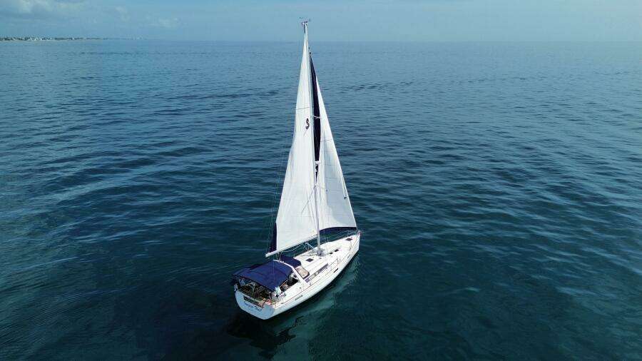 Sailing yacht Beneteau Oceanis 45, 2015 model, cruising on calm blue waters.
